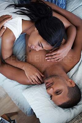 Buy stock photo High angle shot of a content young couple lying in bed