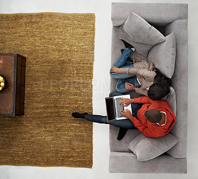 Buy stock photo High angle shot of a young couple sitting on their sofa using a laptop