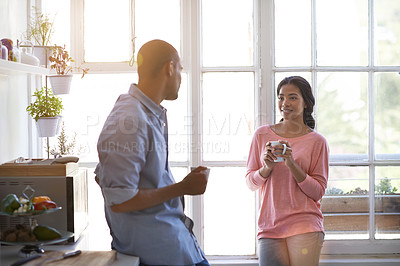 Buy stock photo Shot of a young couple talking and drinking coffee in the kitchen