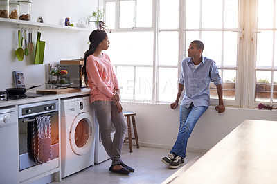 Buy stock photo Shot of a young couple talking in the kitchen