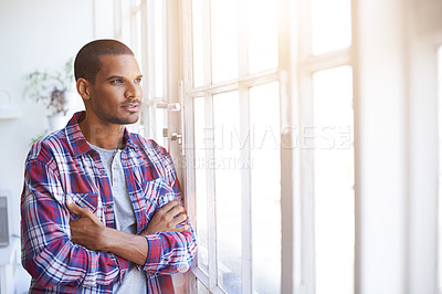 Buy stock photo Cropped shot of a young man looking out of the kitchen window