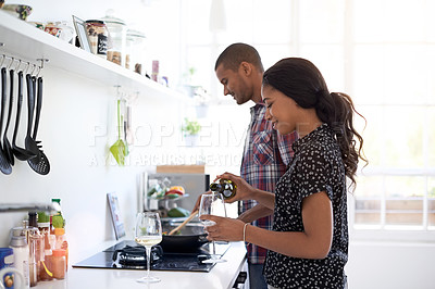 Buy stock photo Shot of a young couple preparing dinner in their kitchen