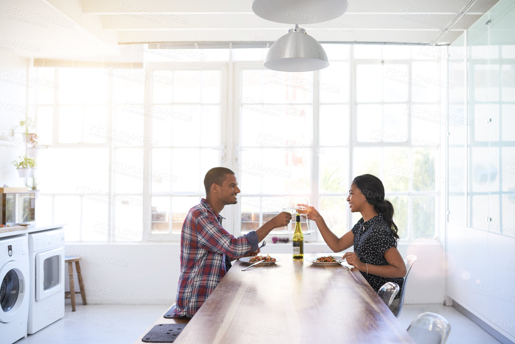 Buy stock photo Couple, cheers or wine with smile at dinner, meal together or anniversary celebration in home. Happy woman, man and drink toast for relationship milestone, food and bonding for love, care and romance