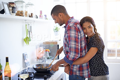 Buy stock photo Shot of an affectionate young couple preparing dinner in their kitchen