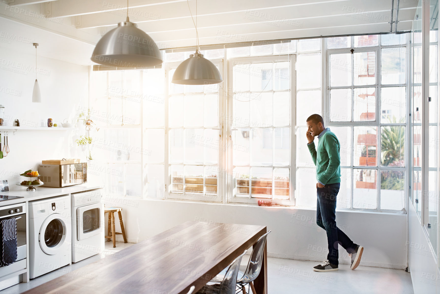 Buy stock photo Smile, phone call and man at kitchen for talking, funny story or communication with contact. Mobile, happy male person and listen to conversation in home, laughing and response for weekend plan