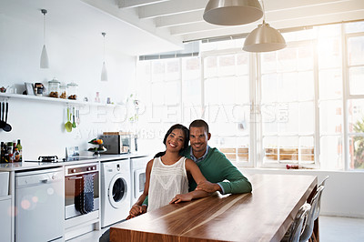 Buy stock photo Portrait of a smiling young couple sitting in their kitchen