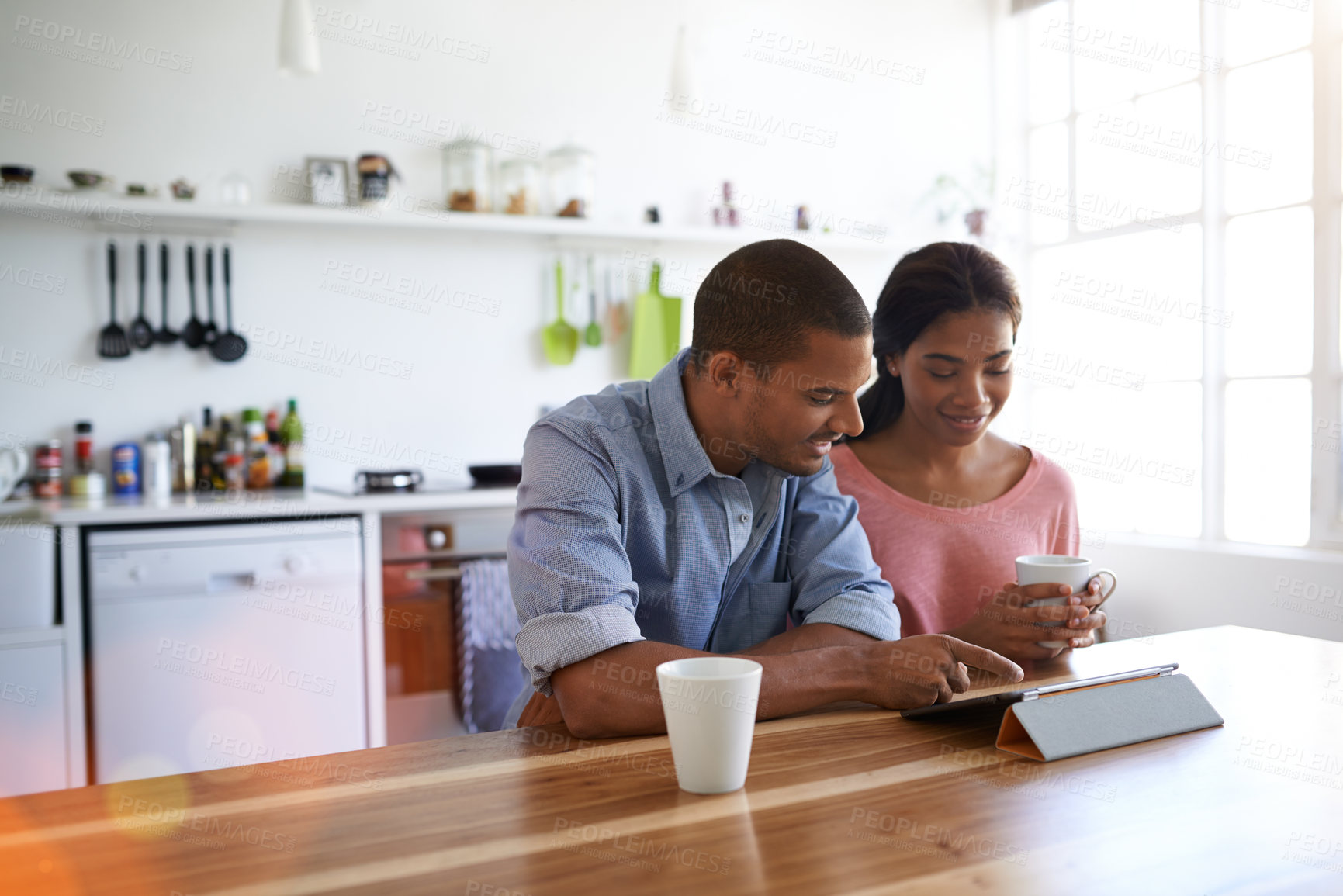 Buy stock photo Couple, relax and coffee at house with tablet, social media and streaming for morning news. Smile, people and beverage in kitchen with digital, browsing website and watching movies for weekend unwind