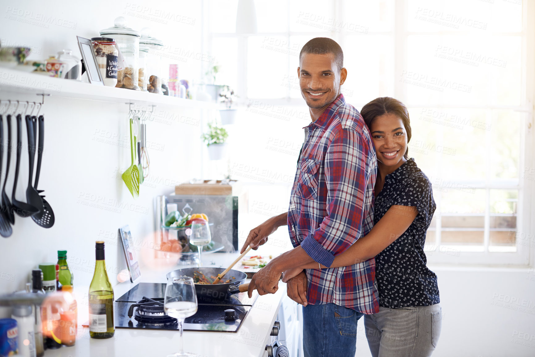 Buy stock photo Hug, happy couple and cooking in home for love, organic food and stir fry with pan on stove. Meal prep, man and woman embrace at kitchen for healthy diet, relationship wellness or smile with portrait