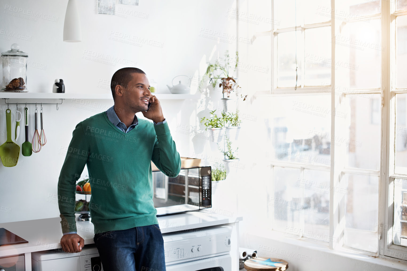 Buy stock photo Smile, phone call or man in home to listen, remote work or schedule update for event planning. Mobile, Indian person and talk in kitchen, communication or freelancer networking for venue coordination