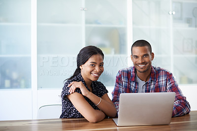 Buy stock photo Portrait of a young couple sitting at their dining table using a latpop
