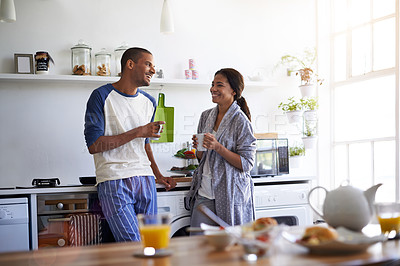 Buy stock photo Shot of a young couple talking and drinking coffee in the kitchen