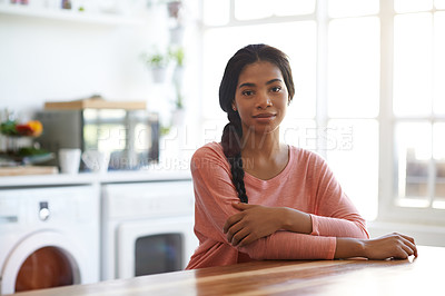 Buy stock photo Portrait of a young woman sitting at her kitchen table