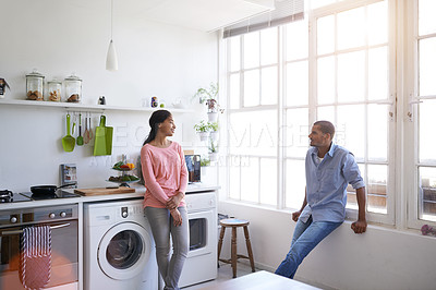 Buy stock photo Shot of a young couple talking in the kitchen