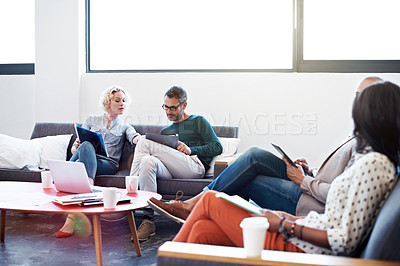 Buy stock photo Shot of a group of coworkers talking together in a modern office
