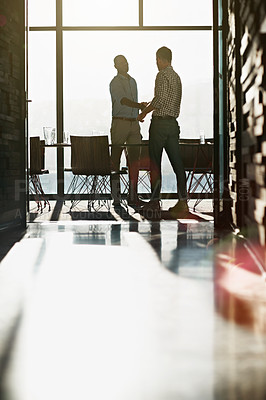 Buy stock photo Shot of two businessmen shaking hands in an office