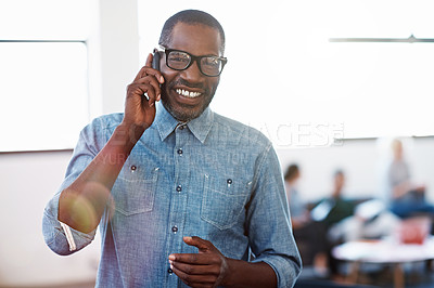 Buy stock photo Portrait of a smiling man standing in an office talking on a cellphone