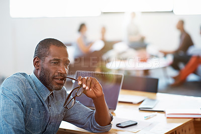 Buy stock photo Shot of a handsome businessman looking thoughtful while sitting in his office