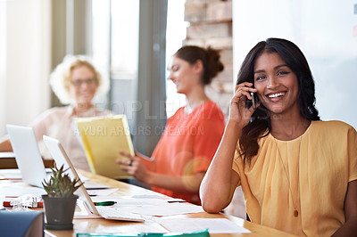 Buy stock photo Shot of an attractive young woman talking on the phone in her office