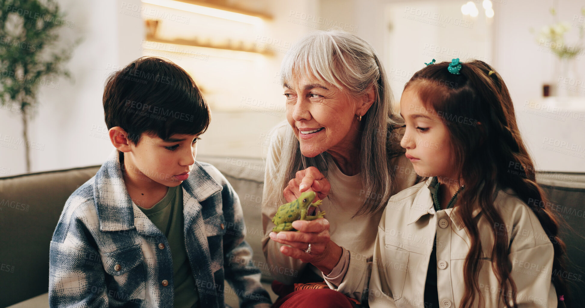 Buy stock photo Happy, frog and grandmother with children on sofa for bonding, love and connection for visit. Family, relationship and kids with grandma for conversation, care and learning with animal on weekend