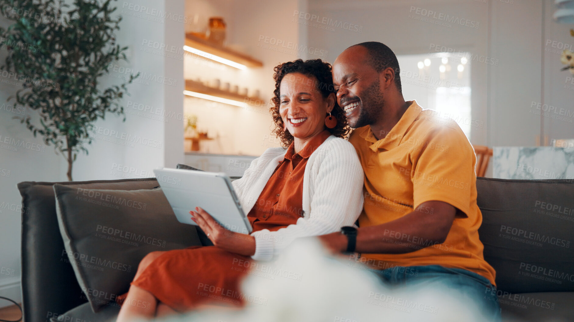 Buy stock photo Couple, bonding and laugh with tablet in lounge, love and streaming film with subscription in house. Entertainment, home and African people with tech for funny movie, relax or watching series on sofa