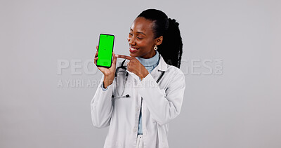 Buy stock photo Green screen, phone and doctor in studio pointing for medical service, health app and mockup. Happy, space and black woman on cellphone for advertising, healthcare and telehealth on white background