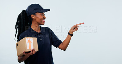 Buy stock photo Pointing, space and black woman in studio for delivery, shipping and advertising for courier service. Mockup, happy and person with box for ecommerce, logistics and information on white background