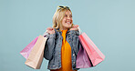 Retail, girl or excited with shopping bags in studio for clothing discount, clearance sale or space. Happy, shopper and designer products on blue background for fashion promo, boutique deal or gifts
