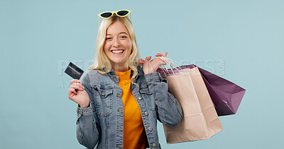 Buy stock photo Happy, girl or shopping bags with credit card in studio for fashion budget, retail sale or space. Portrait, shopper or cashless purchase on blue background for reward points, loyalty program or gifts