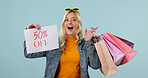 Shopping bags, girl and surprised with sale poster for clothing discount, half price deal or news. Shock, shopper and promo announcement on studio background for retail clearance, bargain or portrait
