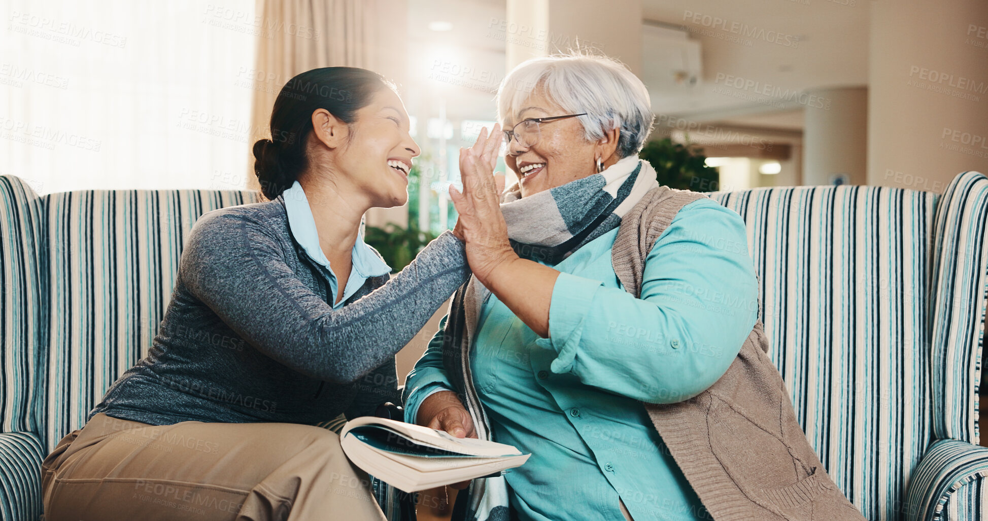 Buy stock photo Caregiver, old woman and high five at house with book, word search and encourage for crossword. Smile, nurse or senior person in lounge with sudoku, answer success and achievement for puzzle activity