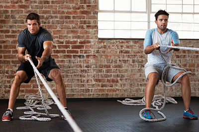 Buy stock photo Shot of two men pulling weights across the floor in a crossfit class