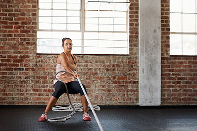 Buy stock photo Shot of a young woman pulling weights across the floor in a crossfit class