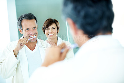 Buy stock photo Couple, mirror and toothbrush to clean for dental care, grooming and morning routine in home. Mature man, woman and smile for brushing teeth, love and wellness or happiness in house bathroom
