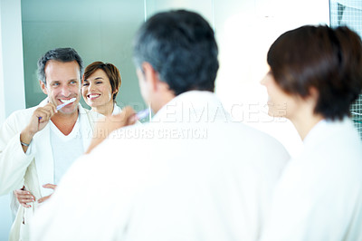 Buy stock photo Couple, hug and toothbrush with mirror for dental care, grooming and morning routine in home. Mature man, woman and smile for brushing teeth, love and wellness or happiness in house bathroom