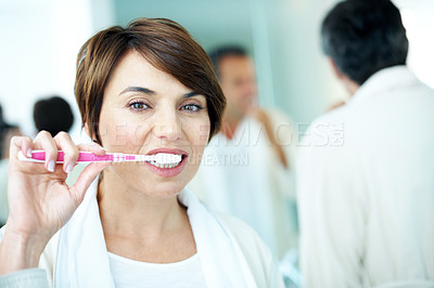 Buy stock photo Dental care, morning routine and woman in bathroom, brushing teeth and grooming with partner in home. Couple, portrait and people with toothbrush for oral hygiene, cleaning and washing mouth in house
