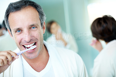 Buy stock photo Dental hygiene, home and man with smile, brushing teeth and morning routine with partner in bathroom. Couple, portrait and mature person with toothbrush for oral care, happy and wash mouth in house
