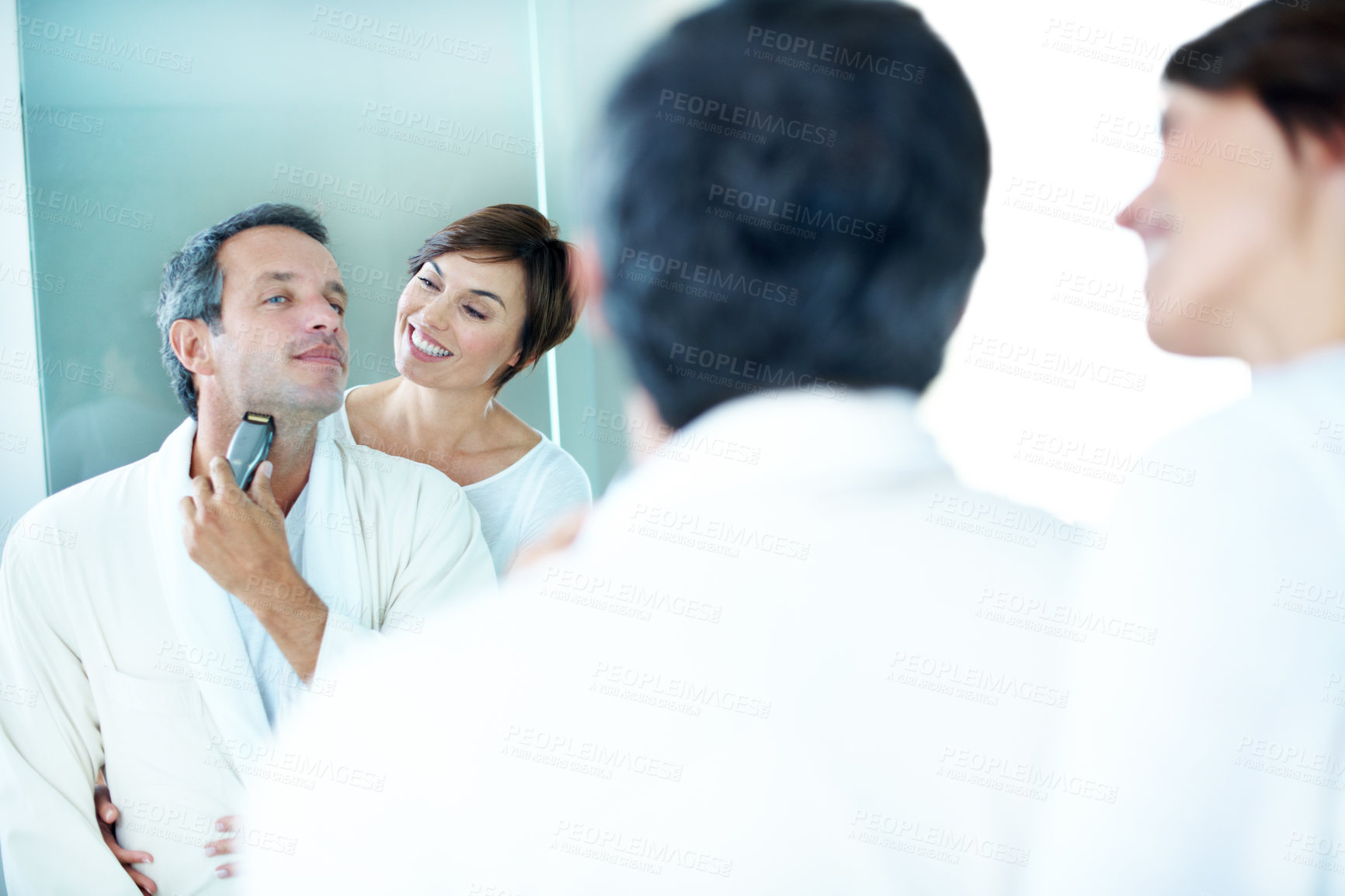 Buy stock photo Mirror, couple and shaving in bathroom with smile, hair removal and grooming for hygiene. Happy, people and reflection at house with trimmer, beard maintenance and facial shaver for morning routine