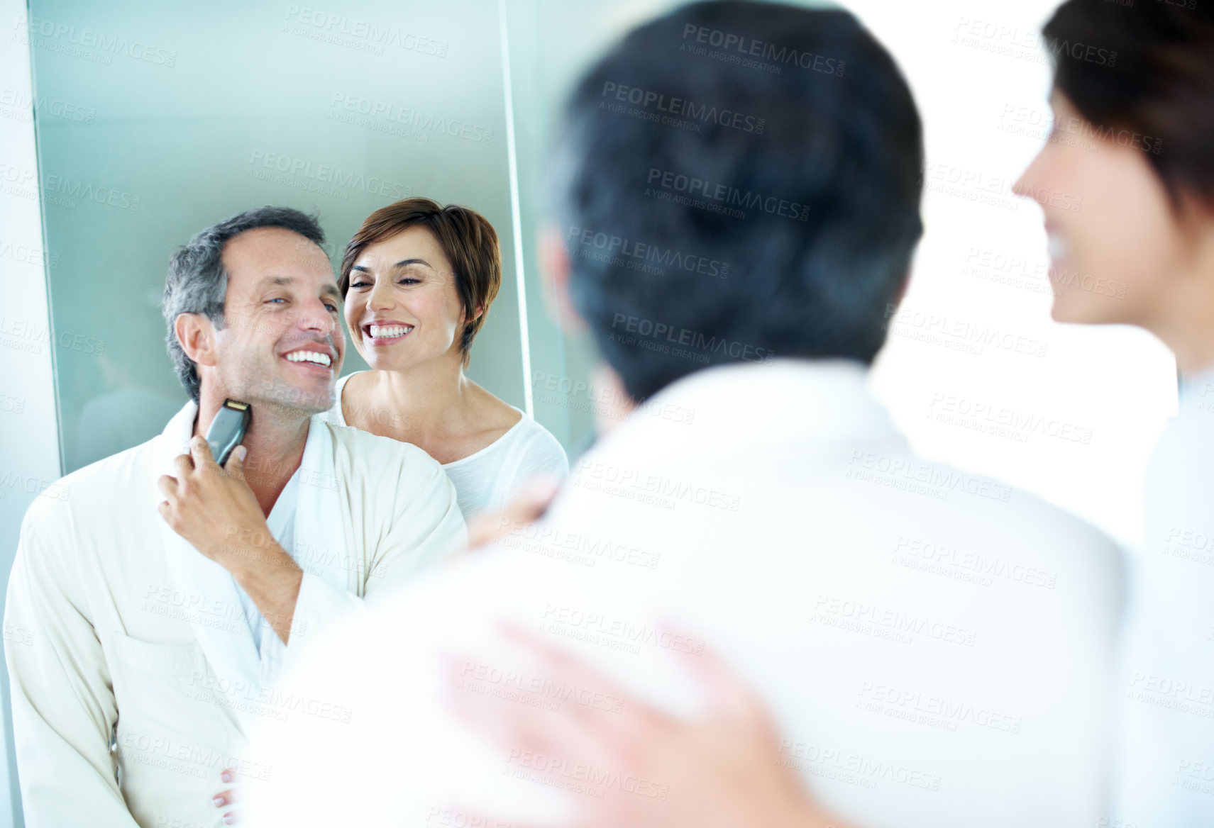 Buy stock photo Happy, couple and shaving in bathroom with mirror, hair removal and grooming for hygiene. Smile, people and reflection at house with trimmer, beard maintenance and facial shaver for morning routine