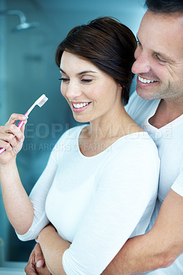Buy stock photo Couple, hug and brushing teeth in bathroom with smile, bonding together or grooming for morning routine. Mature man, woman and embrace in house with toothbrush, oral hygiene and healthy relationship.