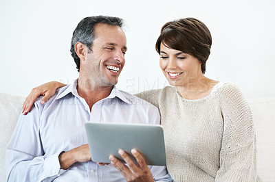 Buy stock photo Sofa, laughing and happy couple with tablet for website, online browsing or entertainment together. Man, woman or smile with technology or humor for fun streaming app, subscription or network service