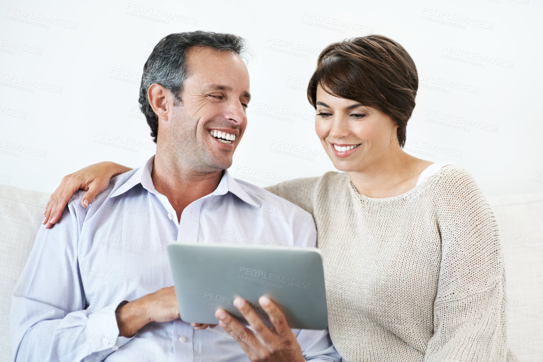 Buy stock photo Sofa, laughing and happy couple with tablet for website, online browsing or entertainment together. Man, woman or smile with technology or humor for fun streaming app, subscription or network service
