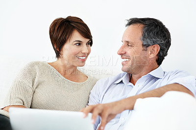 Buy stock photo Couple, talking and happy with laptop on home sofa for online connection, browsing and internet. Mature man, woman and tech in house living room for streaming, subscription or planning on website