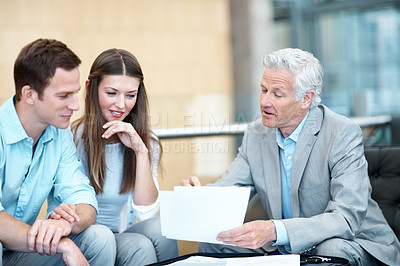 Buy stock photo Couple, meeting and lawyer in office with document, contract and finance report for funding. Smile, people and attorney in workplace with paperwork, review budget and loan application for investment