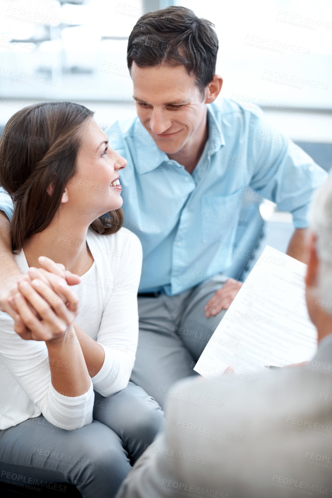 Buy stock photo Couple, smile and holding hands in consultation with insurance agent, financial planning or support. Happy people, dating and policy broker in office with meeting, finance document or risk assessment