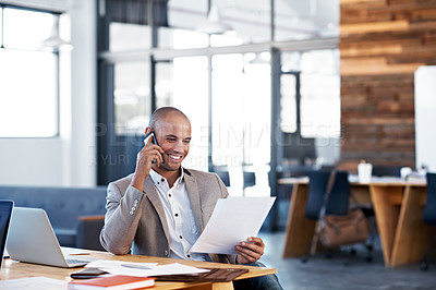 Buy stock photo Shot of a businessman talking on his cellphone while sitting at his desk in an office
