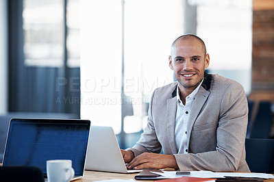 Buy stock photo Portrait of a businessman working on a laptop at his desk in an office
