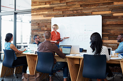 Buy stock photo Shot of a female office worker giving a  financial presentation to her colleagues