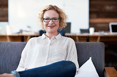 Buy stock photo Portrait of an attractive woman sitting on a sofa in a modern office