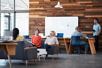 Buy stock photo Shot of colleagues sitting in a modern office