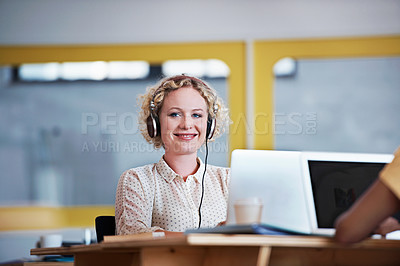 Buy stock photo Portrait of an attractive woman sitting at her desk working on a laptop in a modern office